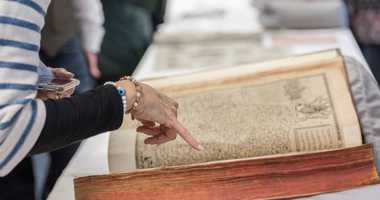 Hand pointing at medieval manuscript