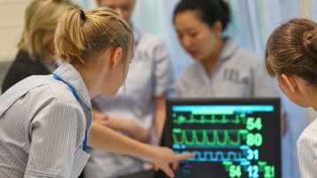 Nursing students doing a practical demonstration with ECG equipment