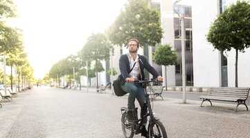 A man on a bike riding on a pedestrianised street