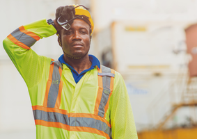 Man in hi-vis clothing wiping away sweat